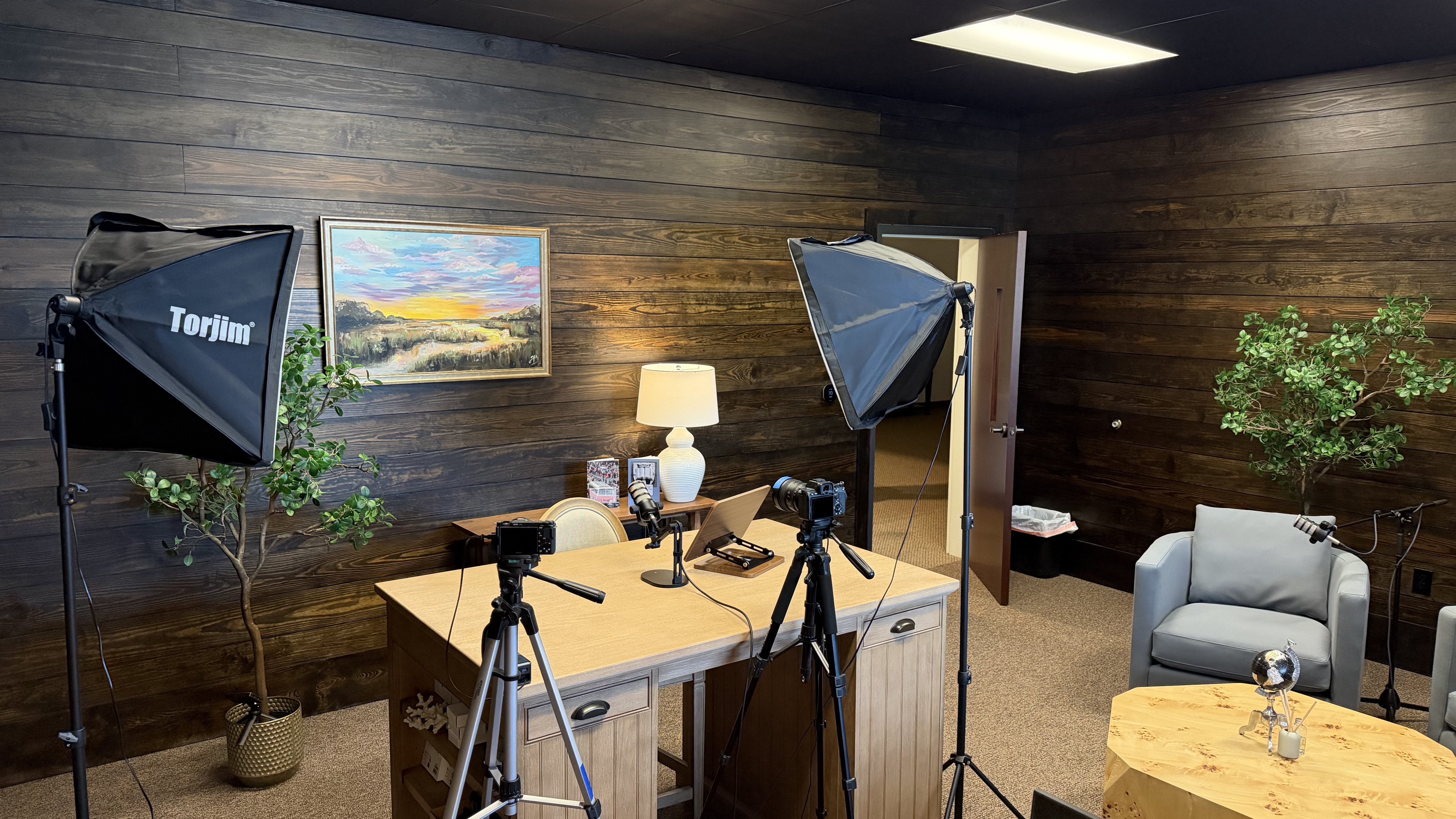 Podcast room set with cameras, lights, microphones, and seating